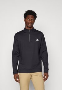 Black quarter-zip pullover made of lightweight fabric, featuring long sleeves and a white adidas logo on the chest. Smooth texture.