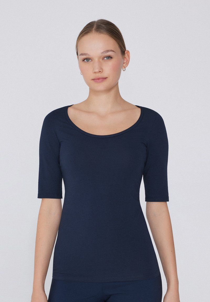 Námorně modrý bavlněný top s kulatým výstřihem a krátkými rukávy. Hladká textura a přiléhavý střih, vhodný pro volnočasové nebo vrstvené outfity.