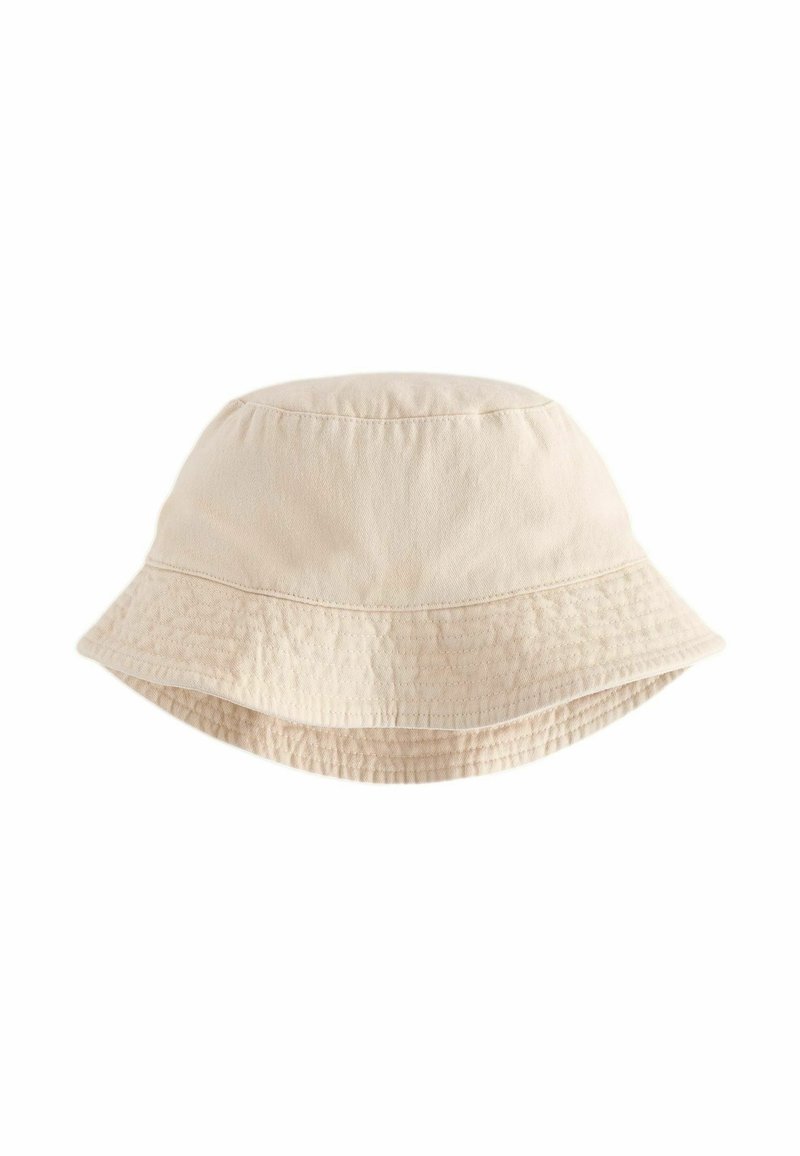 Cappello a secchio in cotone beige con una texture morbida, cupola profonda e ampia visiera floppy. Presenta un delicato dettaglio di cucitura lungo il bordo della visiera.