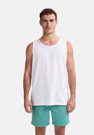 Weißes ärmelloses Tanktop aus leichtem Stoff mit Rundhalsausschnitt. Kombiniert mit türkisfarbenen Shorts für einen lässigen Look.