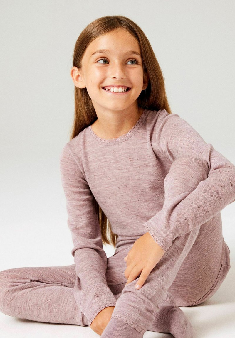 Haut à manches longues couleur lavande claire et leggings assortis, confectionnés en tissu tricoté doux avec un motif subtil, présentant des bords festonnés aux poignets et à l'ourlet.