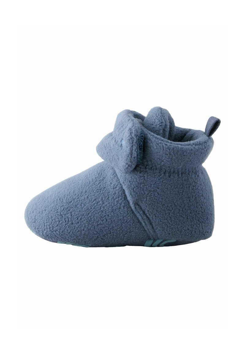 Chausson bébé en polaire bleu doux avec revers et petite boucle en tissu au talon pour un enfilage facile.