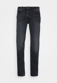 Jeans de ganga azul escuro com um corte reto, desbotamento subtil, cinco bolsos e rebites em cobre. Feitos de algodão com uma textura suave.