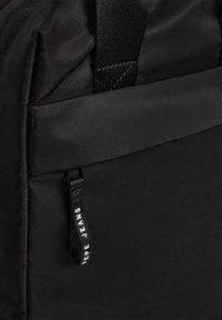 Juodas kuprinė, pagaminta iš lygaus audinio. turi priekinį kišenę, reguliuojamus diržus ir ženklo užtrauktuką su "Pepe Jeans" balta spalva.