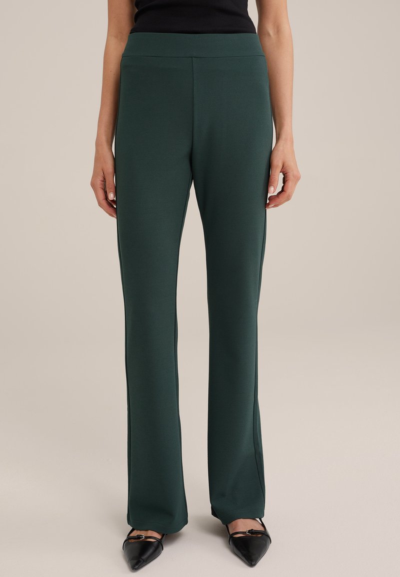 Žalios, aukštu liemeniu kelnės su tiesiu kirpimu, pagamintos iš elastingos medžiagos. Turi lygią tekstūrą ir nematomus akcentus.