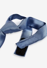 Nœud papillon en satin bleu avec une surface texturée, doté d'une fermeture Velcro pour un ajustement facile. Le design présente une forme classique et une finition lisse.