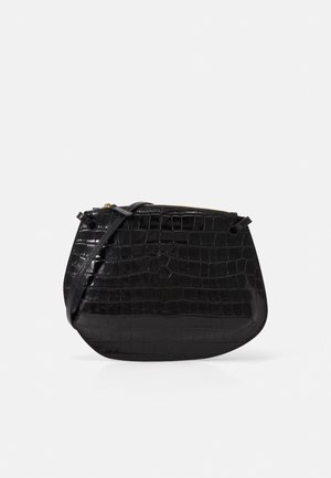 Sort læder crossbody taske med krokodilletekstur og lynlås lukning på en ensfarvet lys baggrund.