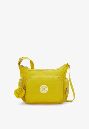 Bolso de hombro amarillo de nylon con un compartimento principal con cremallera, bolsillo delantero y un llavero de mono peludo. Cuenta con una correa ajustable.