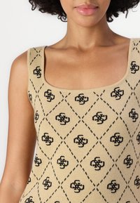 Bežinis megztas tank top'as su kvadratiniu iškirpimu ir deimanto raštu su juodais geometriniais motyvais. Minkšta tekstūra su plačiomis petnešomis.