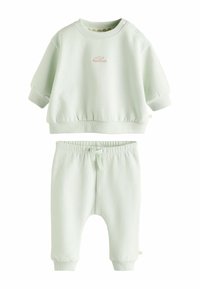 Lysegrøn bomuldsoutfit til småbørn bestående af en kortærmet sweatshirt med rund hals og matchende bukser med elastisk liv og manchetter.