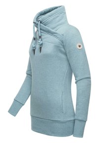 Sudadera azul clara en tela suave y texturizada. Cuenta con un alto cuello, cierre con cordón y un parche con el logo en la manga.