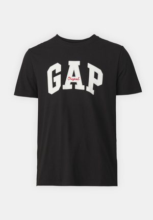 Svart bomull T-skjorte med rund hals, som har store hvite "GAP" bokstaver og en liten rød "Original" detalj. Korte ermer, avslappet passform.