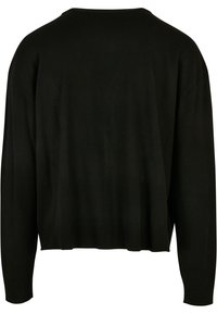 Pulover negru, cu mâneci lungi, cu o croială lejeră. Prezintă un decolteu rotund și un tiv ribat. Materialul pare moale, potrivit pentru îmbrăcămintea casual.