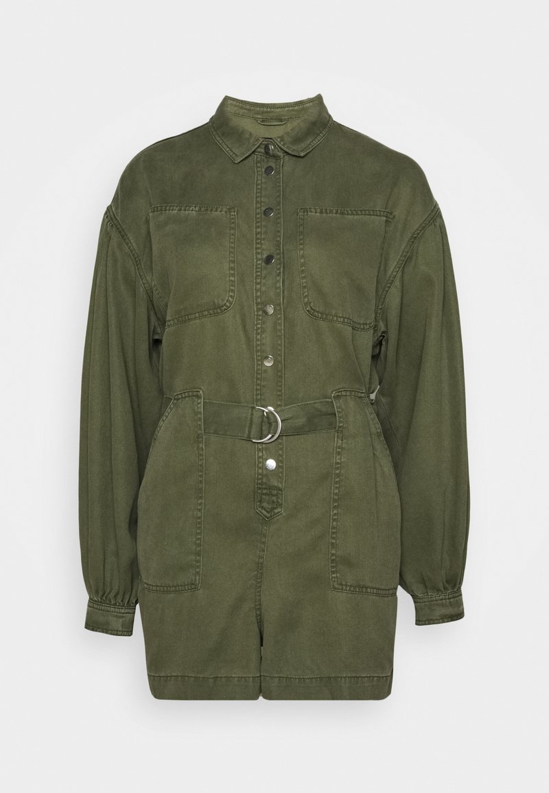 Zielono-oliwkowy dżinsowy kombinezon z zapięciem na guziki z przodu, dwoma kieszeniami na piersi, paskiem w talii z srebrnym pierścieniem oraz długimi rękawami zgromadzonymi przy mankietach.