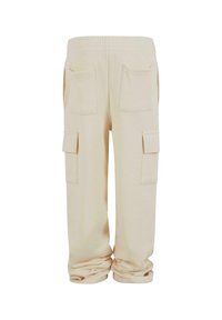 Pantalons cargo beige avec une coupe décontractée, dotés d'une taille élastique, de deux poches latérales et de deux poches arrière. Tissu doux et texturé.