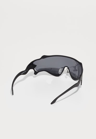 Lunettes de soleil de sport noires avec un design enveloppant, verres gris et des montures légères et élégantes. Équipées de coussinets de nez ajustables pour plus de confort.