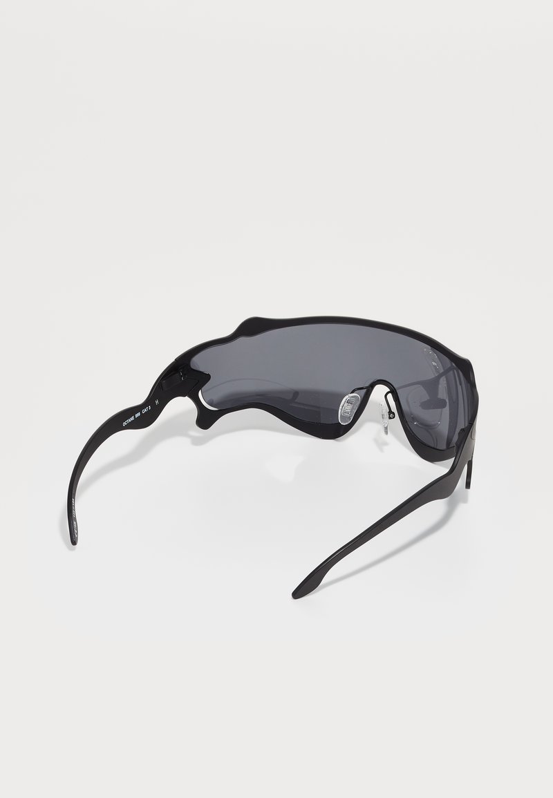 Black sports sunglasses with a wrapped design, gray lenses, and sleek, lightweight frames. Features adjustable nose pads for comfort.