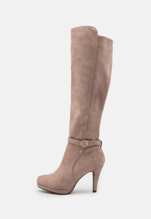 Botte mi-haute en daim taupe à texture lisse, talon haut, avec une boucle dorée en accent sur la sangle de la cheville. Conception à bout arrondi.