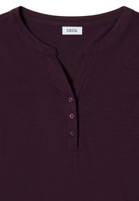 Mørkeblå, kortærmet top med rund halsudskæring, der har en tre-knaps placket og en let struktureret stof. Mærkeetiket synlig.