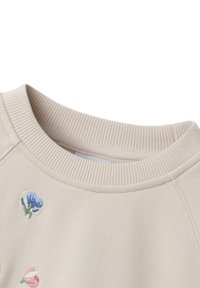 Beige sweatshirt met ribbelboord en geborduurde bloemenontwerpen in blauw en roze. Zachte textuur en casual ontwerp.