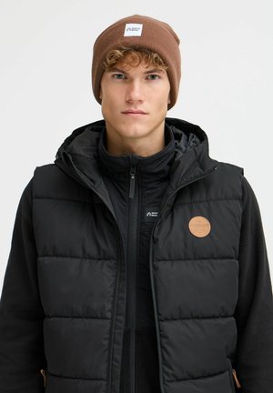 Must must vest, mille ja kapuutsiga, sisaldab nahast logo patchi ja tõmblukku. Täiendatud pruuni punutud mütsiga.