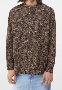 Långärmad skjorta i brunt tyg med ett ljust beige blommönster, med krage och knappslå, avslappnad passform.