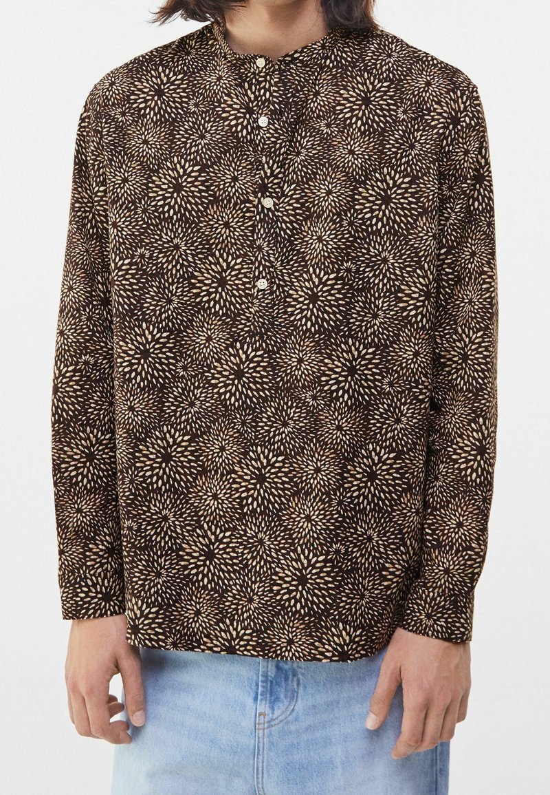 Långärmad skjorta i brunt tyg med ett ljust beige blommönster, med krage och knappslå, avslappnad passform.