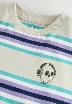 Sweatshirt en coton rayé de couleur crème, avec des rayures teal, violet et marine. Imprimé graphique d'une tête de mort avec des écouteurs à l'avant.