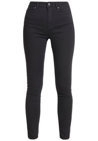 Jeans skinny negros hechos de una mezcla de algodón elástico. Cuenta con cinco bolsillos, una cremallera frontal y un cierre de botón. Textura suave.