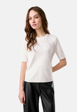 Weißer kurzärmeliger Pullover mit Rundhalsausschnitt, der auf der Vorderseite ein strukturiertes Muster aus kleinen Perlen aufweist. Glattes Strickmaterial und lockere Passform.