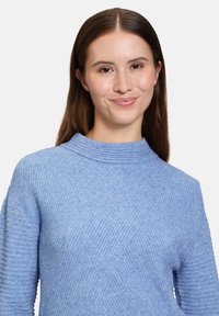 Helles blaues geripptes Sweatshirt mit einem hohen Kragen und diagonalen Strukturmustern. Weicher, mittelschwerer Stoff mit langen Ärmeln.