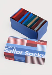 Männermatrosensocken in einer blauen Box mit acht Paaren in verschiedenen Farben: rot, blau, grün, braun. Die Box hat ein gestreiftes Design und ein Etikett.