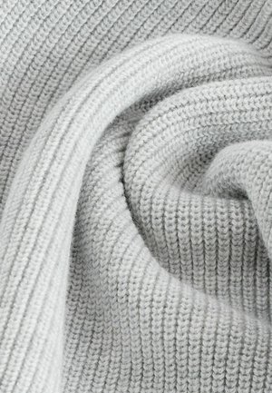 Tessuto a maglia grigio chiaro con una texture a coste, che mostra una superficie morbida e leggermente pelosa e una piega a spirale, enfatizzando il suo spessore e calore.