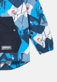 Farebná detská lyžiarska bunda v modro-bielej farbe. Obsahuje grafický vzor so zvieratami, horami a stromami. Tmavo námornícky vrecko s logom.