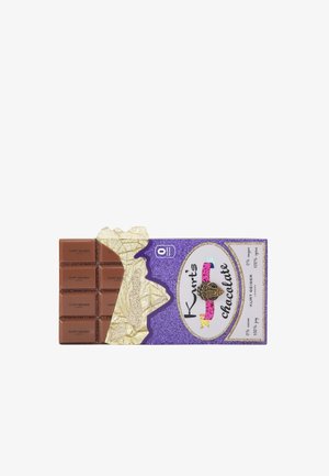 Barretta di cioccolato con otto pezzi rettangolari con "Kurt Geiger" in rilievo. Il packaging è di un viola glitterato con accenti dorati e elementi decorativi.