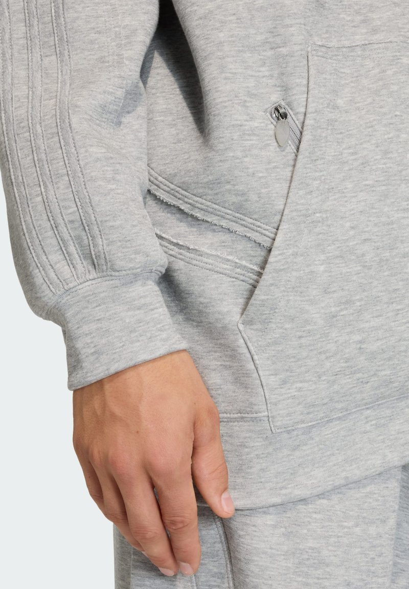 Grå sweatshirt med lynlåslomme, teksturerede ærmedetaljer og blød stoffinish, med ribbede manchetter og kant.