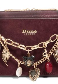 Burgundy suede handbag with gold-tone hardware, featuring a chain strap, and decorative charms including flowers, leaves, and hearts.