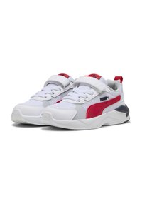 Chaussures de sport blanches en matériaux mesh et synthétiques, avec des accents rouges, une sangle en Velcro et une semelle rembourrée. Présente un panneau latéral texturé.