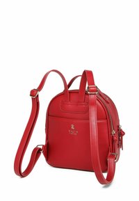 Červený kožený batoh s nastavitelnými popruhy, zlatým zipem a malou přední kapsou s raženým logem VUCH Limited.