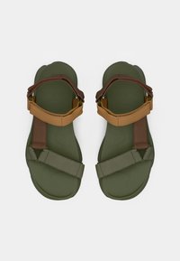 Πράσινα σανδάλια με καφέ και ελιάς λουριά. Κατασκευασμένα από ευέλικτο υλικό, με υφασμένο πέλμα και ρυθμιζόμενο σχεδιασμό λουριών.