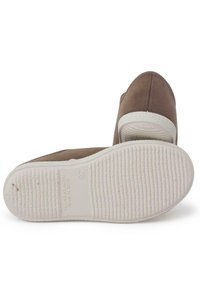 Scarpe in suede marrone con suola in gomma bianca, caratterizzate da una punta arrotondata e un design semplice. La suola ha una texture rigata per garantire aderenza.