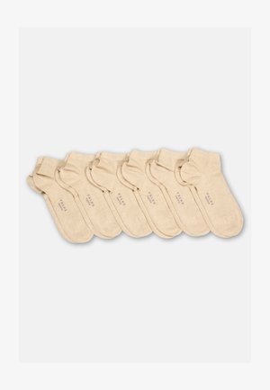 Sette paia di calzini beige alla caviglia, disposti ordinatamente, ciascuno con il testo sottile "FALKE Happy" nella zona della suola.