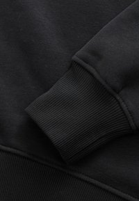 Zwarte sweatshirtstof met een geribbelde manchetdetail. Glad textuur met een zachte afwerking, met een effen kleur en een minimalistisch ontwerp.