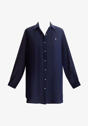 Tamsiai mėlyna marškinėliai iš lengvos medžiagos, su sagomis priekyje, ilgomis rankovėmis ir mažuoju logotipu ant krūtinės.