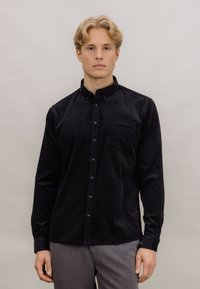 Svart knapp-up skjorte i cord stoff, med en brystlomme, lange ermer og en strukturert krage. Jevn tekstur med en tettsittende design.