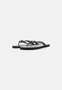 Sorte flip-flops med teksturert grå og hvit mønstret fotseng. Har tynne stropper og flat såle. Enkelt design for uformell bruk.
