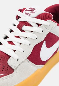 Die Nike SB Force 58 Sneaker verfügen über ein obermaterial aus kastanienbraunem Wildleder und Canvas, weiße Lederelemente und eine Gummisohle mit strukturierten Details.