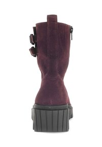 Burgundy suede ankle boots with a high platform sole, featuring side zippers and buckle accents. Textured rubber bottom for grip.
