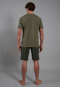 Camiseta de manga corta verde oliva y pantalones cortos a juego, ambos hechos de una tela suave y ligera, con un ajuste relajado y sin patrones visibles.