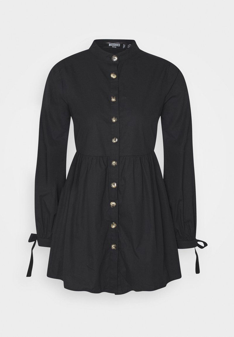 Svart knäppt klänning, långa ärmar med knytdetaljer, midjan är åtdragen, tillverkad av slätt tyg. Har guldfärgade knappar fram.